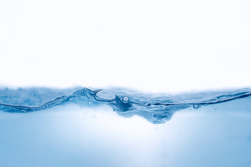 Closeup view of dynamic flowing blue water waves on white background. Liquid splash. Texture and abstract background