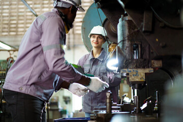 Team of mechanical engineers are performing inspection on heavy machines in workshop - factory.
