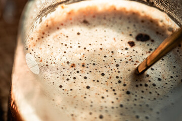 cappuccino mocha coffee with foam in a glass macro under sunny morning light, morning coffee,...