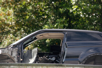 Black SUV with significant damage visible at an outdoor location during daylight hours