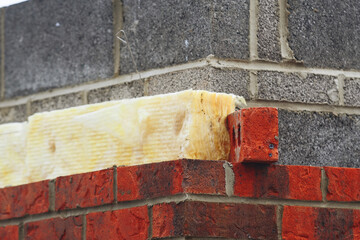 Close-up of Construction of a brick wall with insulation material at a building site during...