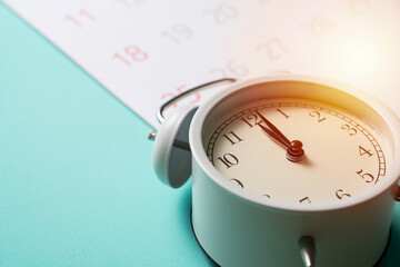 close up of calendar and alarm clock on the green table background, planning for business meeting or travel planning concept