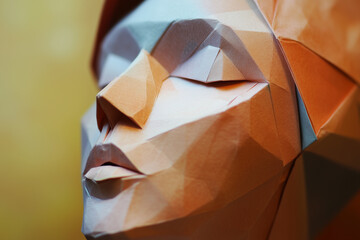 An abstract geometric face sculpture in warm tones. Generative AI