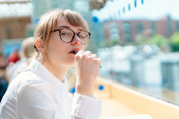 Young woman enjoying quiet moment at cafe on sunny day while deep in thought