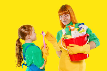 Engaging cleaning activity brings joy to mother and daughter on bright yellow background