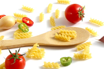 Fresh ripe harvest of vegetables lies on white isolated background with dry pasta before cooking.