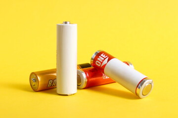 Many saline batteries lie on a yellow background.