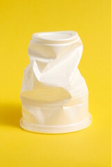 On the yellow one there is a white plastic cup, crumpled and dented.