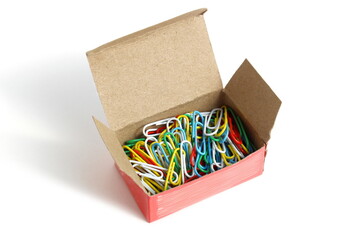 There is a pile of multi-colored paper clips in a cardboard box.
