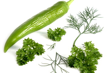 Green pepper, parsley and dill lie on a white background.