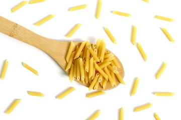 A pile of dry pasta lies on a wooden spoon on a white background.