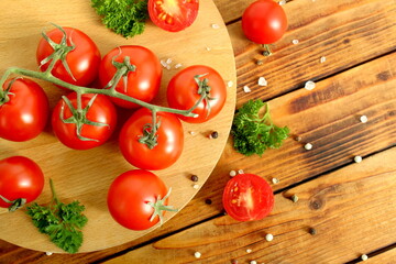 Cherry tomatoes branch lie on a wooden table