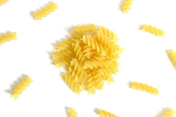 A pile of dry pasta lies on a white background.