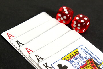 On a black background lies a deck of poker playing cards with dice.