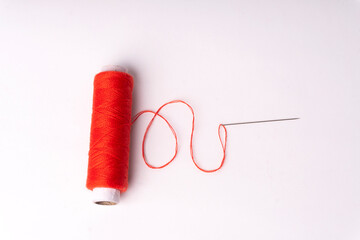 Colorful sewing thread set and needles isolated on background.
