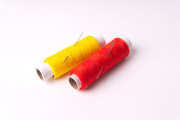 Colorful sewing thread set and needles isolated on background.
