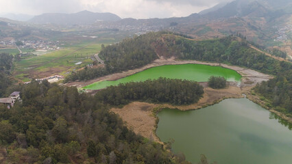 Naklejka premium volcanic sulfur lake telaga warna in dieng plateau, java Indonesia. mountain tropical landscape lake with green water among mountains. this lake is one mainstay tourist destinations in Wonosobo