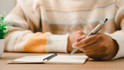 Male hand taking notes on the notepad. businessman working at work table, checklist writing...