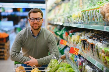 Handsome man shopping in a supermarket