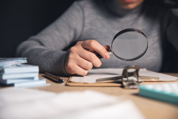 woman with magnifying glass on document