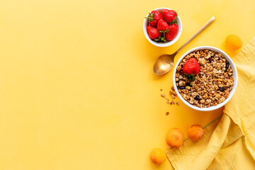 Bowl of cereal granola with strawberry and honey for breakfast, top view