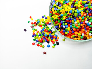 Rainbow masterbatch plastic granules, polymer carries pigment in a glass cup poured with a white background, suitable for product catalog design of industrial plastic manufacturing company profiles