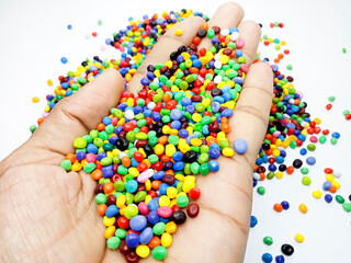 Plastic masterbatch mix color granules in open hand grip, polymer carrying colorful pigments...