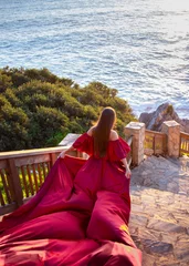 Gordijnen Bordeaux Ocean Dream: Woman in a Red Dress at Sunset  © Reghina