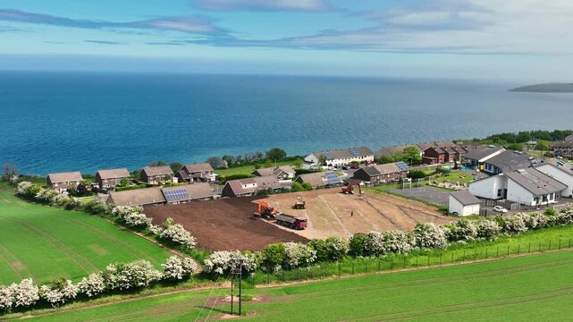 Slow motion aerial view of machinery at construction of sports fields Corran Integrated Primary School Larne N. Ireland 10-02-20 