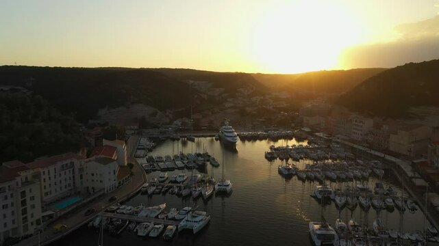 4K video of the rays of the setting sun illuminate a cozy sea bay with a marina in the old town
