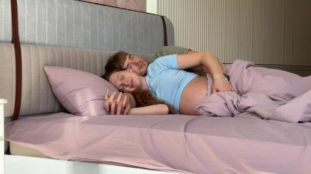 beautiful young couple in love man and pregnant woman in bed in the morning, enjoying each other. concept happy relationship