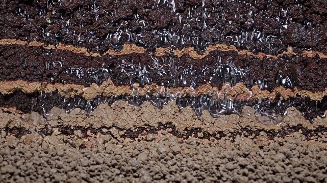 Slow Motion Shot of Soil Cross-Section | Static Shot Fixed Camera Movement | Front View of Underground Water Flow | Visible Layers of Earth and Rocks | Detailed Geological Structure | Natural