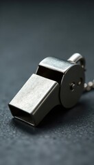 Classic metal whistle; gray background, close-up view, blow, call, chrome