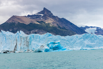Perito Moreno famous glacier in Patagonia, EL Calafate, Argentina. Deep blue ice of the growing and moving glacier, stunning walls of ice and icebergs floating in the turquoise lake below the glacier 