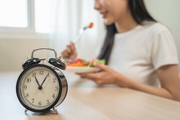 Intermittent fasting with clock, close up young woman, girl diet, waiting time to eat ketogenic low...