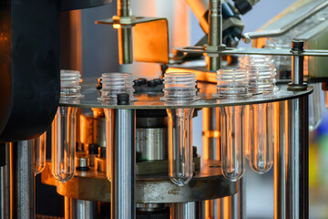 Conveyor belt deliver the preform shape to the  blow mold machine.