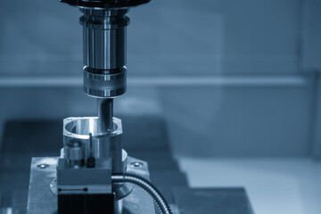 The CNC milling machine chamfer cutting aluminum part by chamfer tool in the light blue scene.