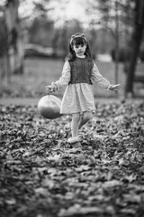 little girl playing in autumn park