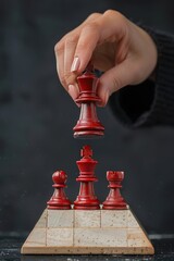 Woman puts a glossy red chess king figure on top of a pyramid, black background
