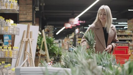 Girl shopping thoughtfully in a busy supermarket filled with fresh produce and diverse food options