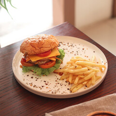Enjoying a tasty cheeseburger accompanied by golden fries on a sunny day in a cozy setting, perfect for a casual meal