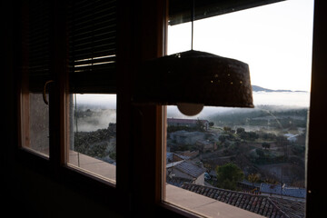 window with rustic chamber, foggy landscape and winter cold through the glass.