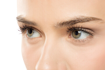 Fototapeta premium Extreme close-up of clear, hazel-green eyes with defined lashes, showcasing natural beauty and subtle makeup details