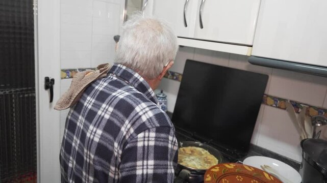 old man spinning vegetable omelette, eighty year old person in a checked shirt, living alone and cooking