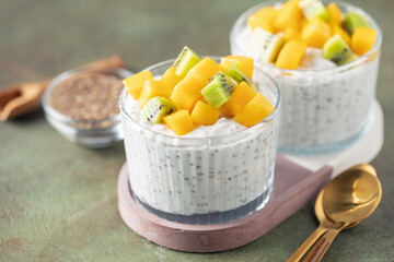 Chia seed pudding from coconut milk with mango cubes and kiwi fruit  in glass bowl. Vegan  food. Clean eating concept