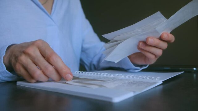 Accountant reviews receipts and invoices, carefully organizing them for a comprehensive monthly expense report, ensuring accuracy and compliance. Woman sort out the accumulated debts on utility bills.