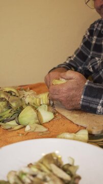 older man's hands cutting tortilla chips, plush plaid shirt.