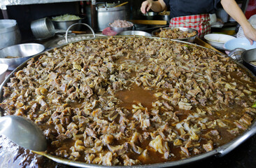Giant pan full of stewed beef and goat meat is seen in a Chinese style beef noodle restaurant in Bangkok, Thailand..