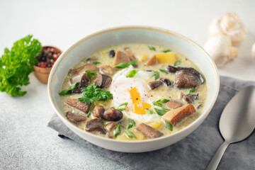 Homemade Kulajda is  traditional Czech thick soup, with mushrooms, potatoes, cream and poached egg  in bowl