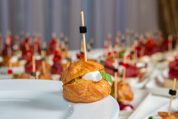Catering buffet or service with different snacks, appetizers and canapes on a table. Variety of...